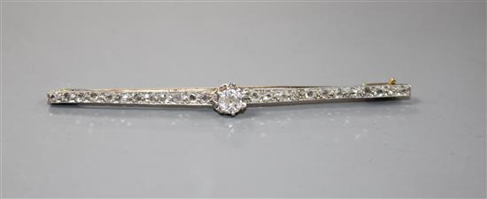 A 1920s yellow and white metal, diamond bar brooch, with central old cut diamond and millegrain set rose cut diamonds,